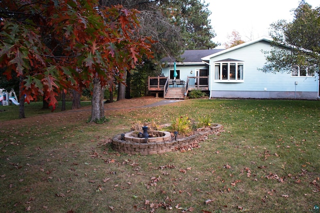 view of yard with a deck and a fire pit