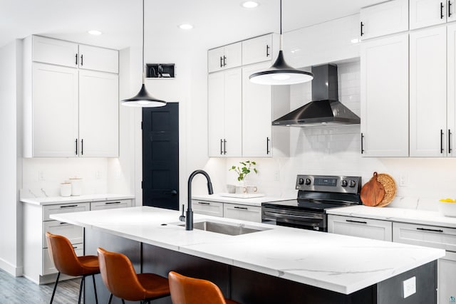 kitchen featuring white cabinetry, wall chimney exhaust hood, hanging light fixtures, and stainless steel electric range