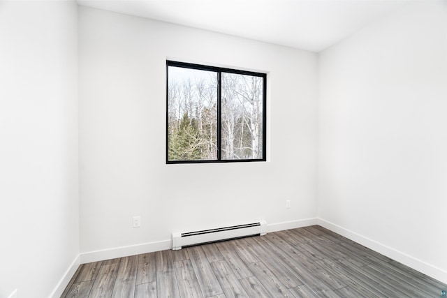 spare room featuring hardwood / wood-style floors and a baseboard radiator