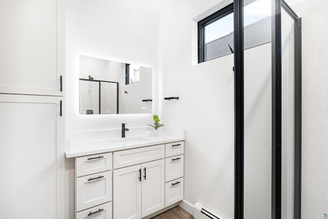 bathroom featuring walk in shower, a baseboard radiator, vanity, and wood-type flooring