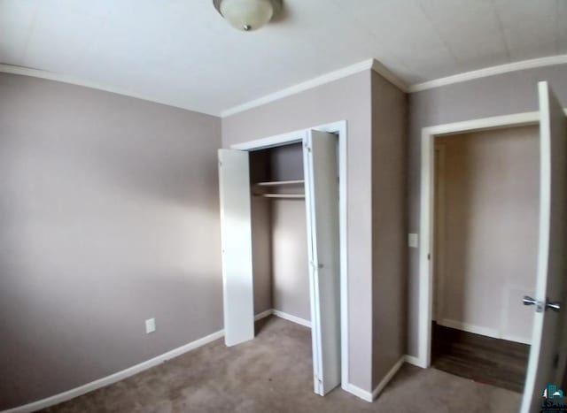 unfurnished bedroom featuring ornamental molding, carpet flooring, and a closet