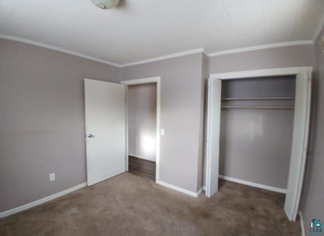 unfurnished bedroom with ornamental molding, carpet floors, and a closet