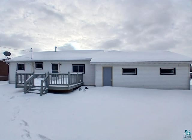 snow covered rear of property featuring a wooden deck