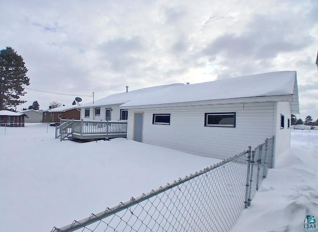 snow covered property featuring a wooden deck