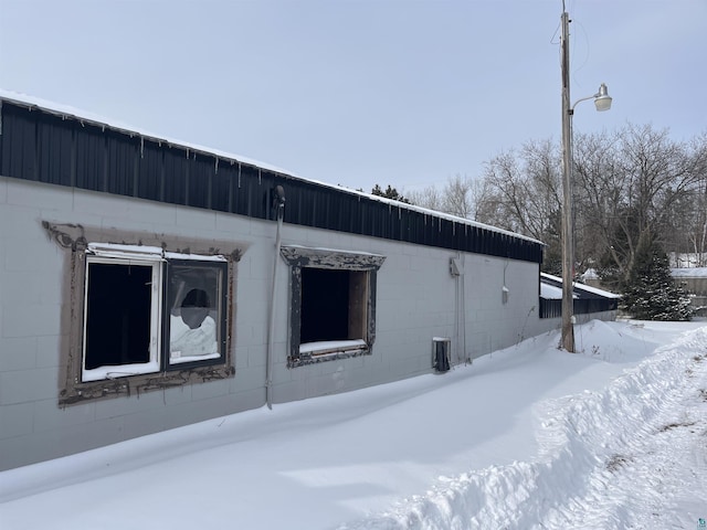 snow covered property featuring concrete block siding