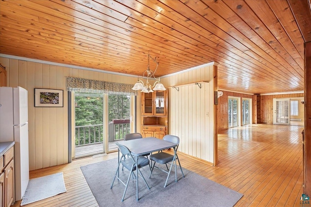 dining area with crown molding, a chandelier, wood ceiling, and light hardwood / wood-style floors