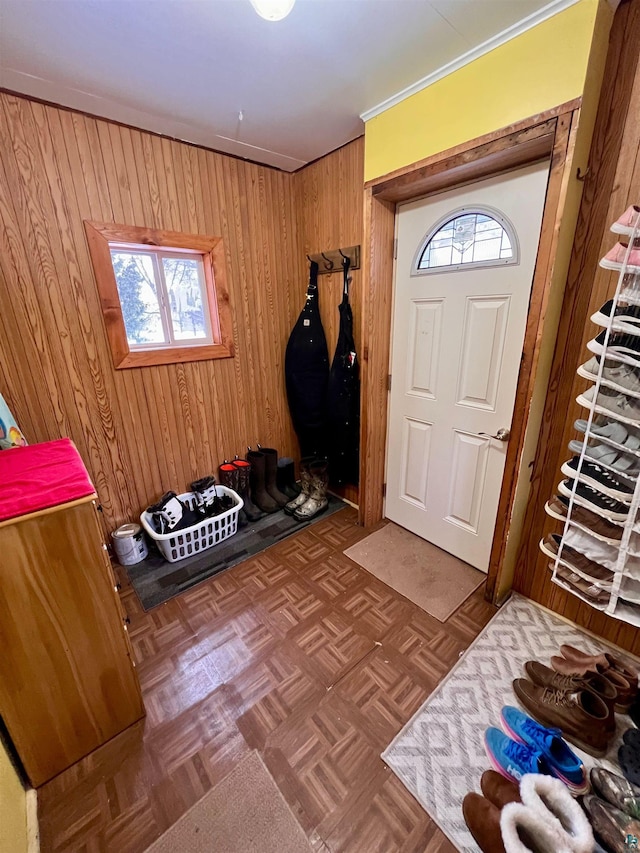 foyer with wooden walls and dark parquet floors