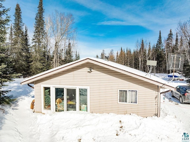 view of snow covered back of property