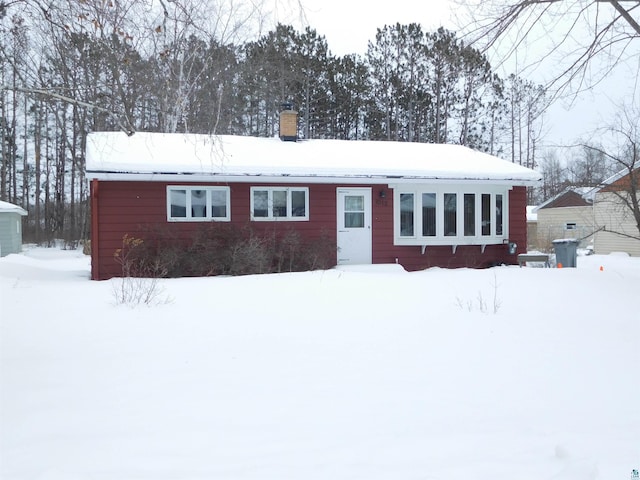 view of snow covered back of property