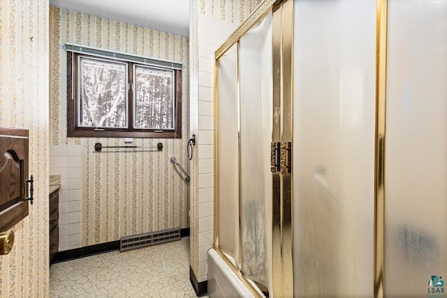 bathroom with bath / shower combo with glass door