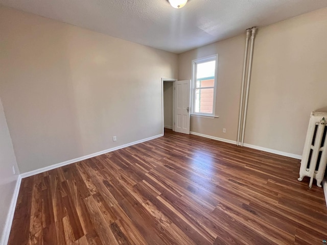 interior space with radiator heating unit, dark hardwood / wood-style flooring, and a textured ceiling