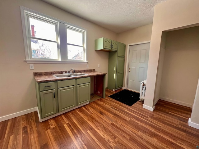 kitchen with sink, a textured ceiling, and dark wood-type flooring