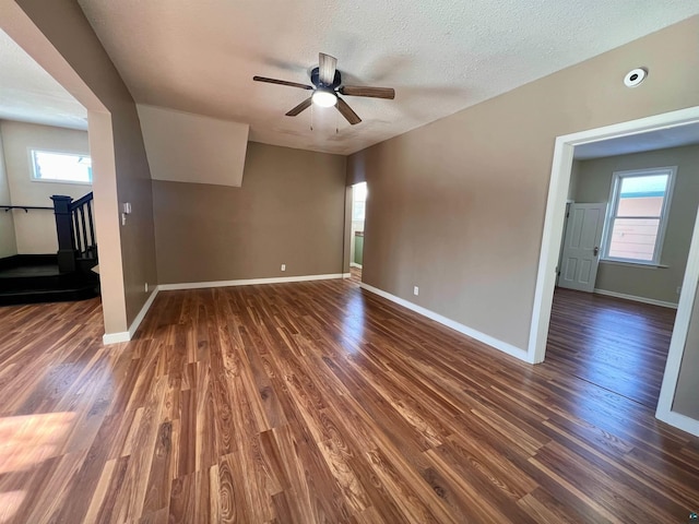 spare room with a textured ceiling, dark wood-type flooring, and ceiling fan