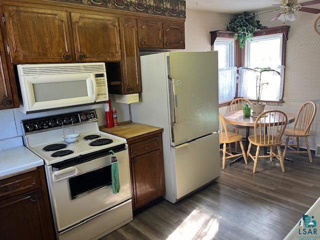 kitchen with ceiling fan, white appliances, and dark hardwood / wood-style floors