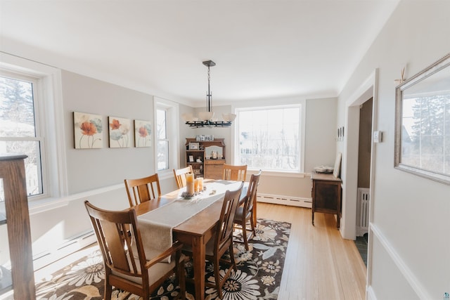 dining room featuring a baseboard heating unit, radiator, a notable chandelier, and light hardwood / wood-style flooring