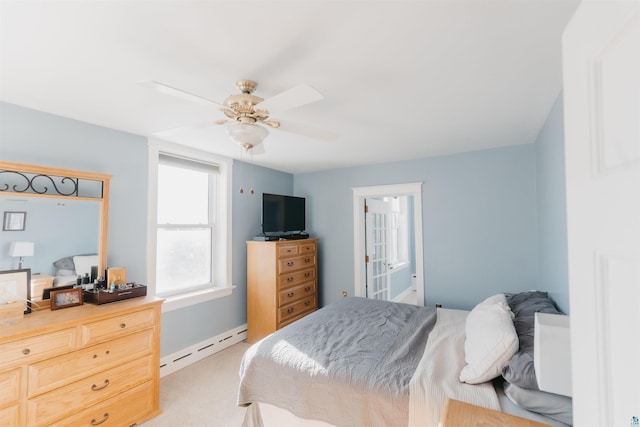 bedroom with ensuite bath, ceiling fan, a baseboard heating unit, and light colored carpet