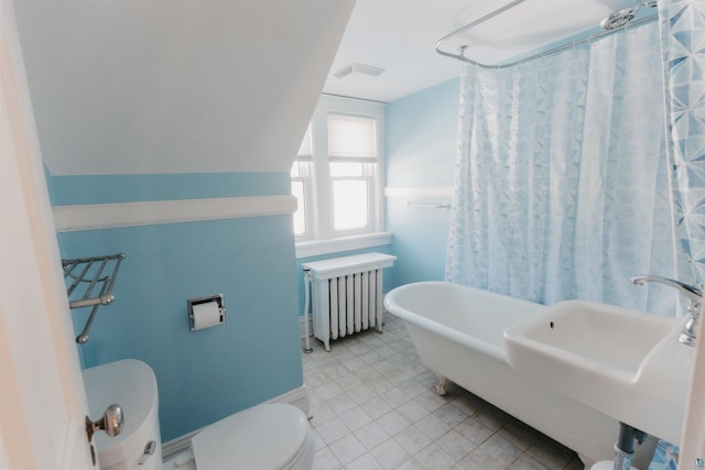 bathroom with radiator, toilet, vaulted ceiling, sink, and a bathtub