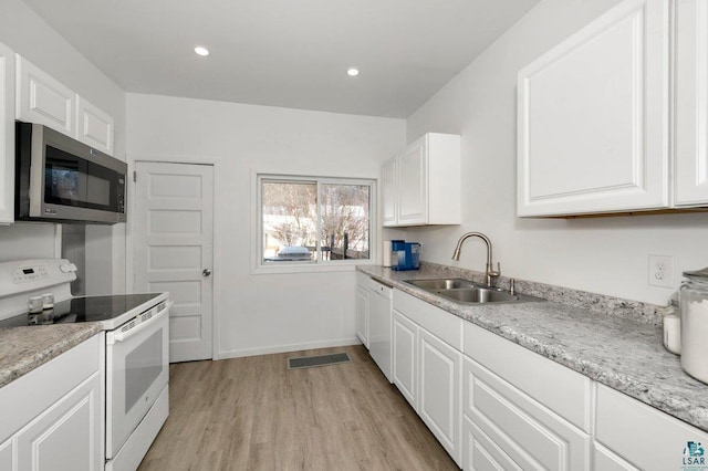 kitchen featuring white appliances, light hardwood / wood-style floors, sink, and white cabinets