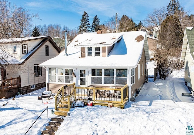 view of front of house featuring a chimney and a sunroom