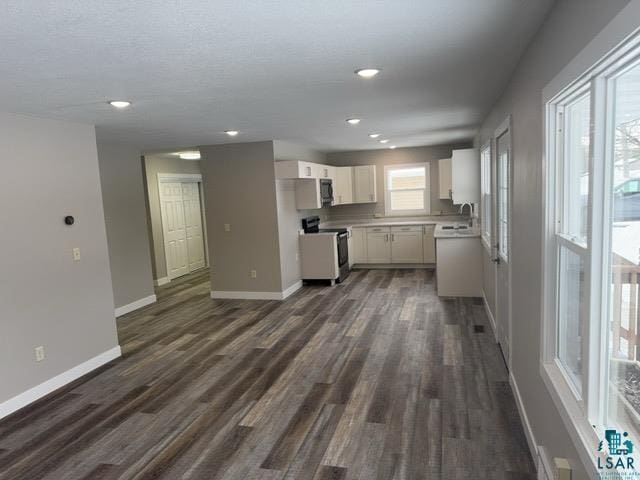 kitchen featuring sink, stainless steel electric range oven, white cabinets, and dark hardwood / wood-style flooring