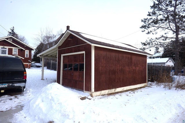 snow covered structure with a garage