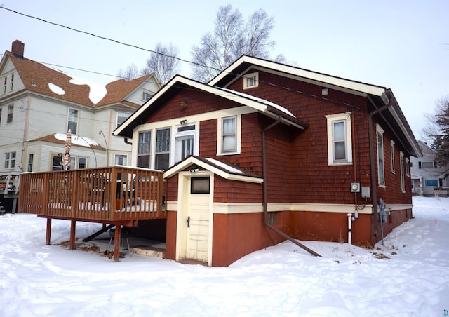 snow covered property with a wooden deck