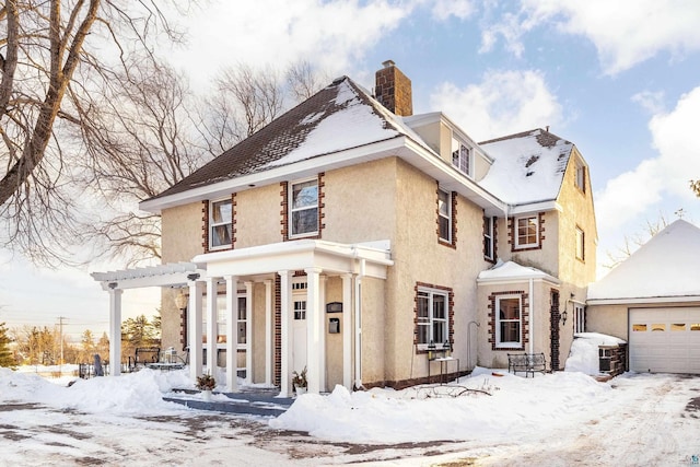 view of front of house with stucco siding and a chimney