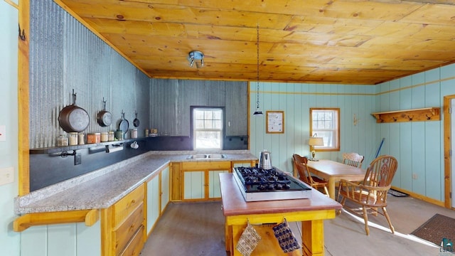 kitchen featuring wood ceiling, light countertops, stainless steel gas cooktop, and a sink