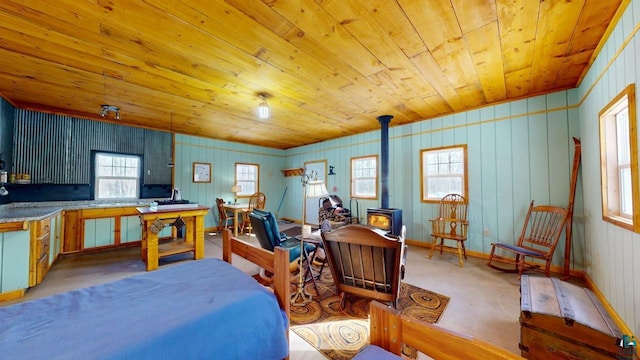 bedroom with a wood stove, wood ceiling, baseboards, and light colored carpet