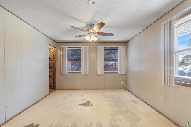 spare room with a textured ceiling, plenty of natural light, and crown molding