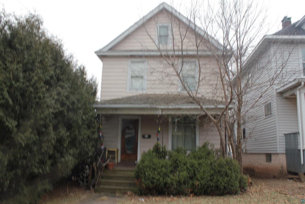 american foursquare style home with a porch