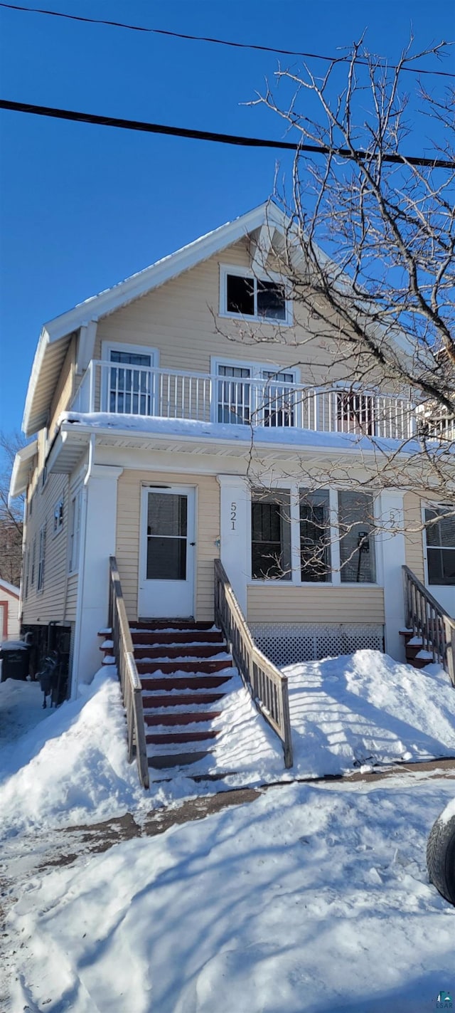 view of front of home featuring a balcony and entry steps