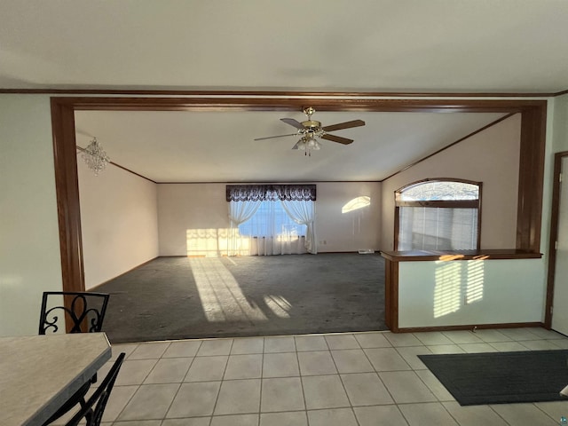 unfurnished living room with light carpet, ceiling fan, ornamental molding, and light tile patterned flooring