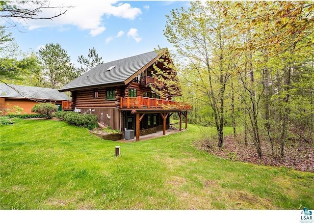 back of property featuring a wooden deck, log exterior, and a yard