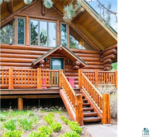 exterior space featuring stairway, log exterior, and a wooden deck