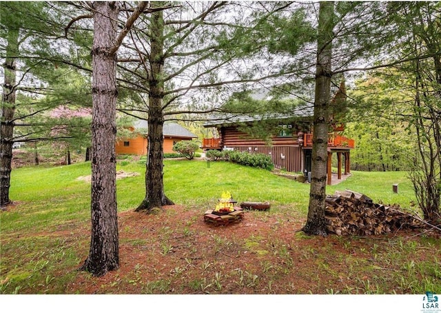 view of yard with a deck and a fire pit