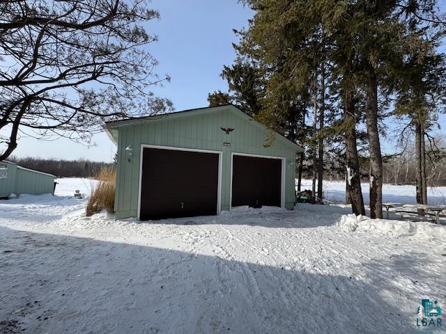 snow covered garage with a garage