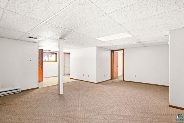 basement featuring carpet floors, a baseboard radiator, visible vents, and a paneled ceiling