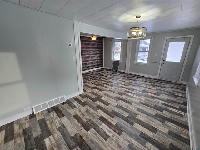 foyer with dark wood-style flooring, visible vents, baseboards, and an inviting chandelier