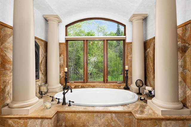 full bath with a tub to relax in and decorative columns