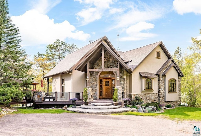 view of front of home featuring stone siding, a wooden deck, and stucco siding