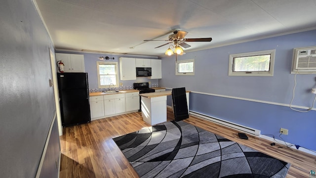 kitchen featuring black appliances, white cabinetry, baseboard heating, and a sink