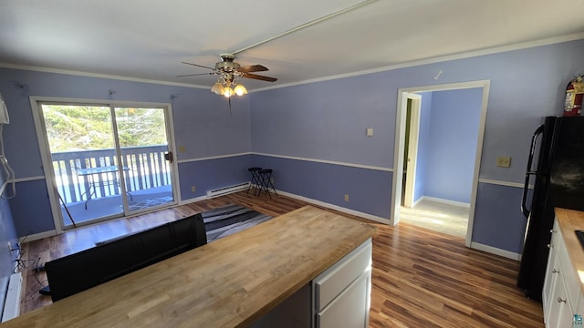 kitchen with wood finished floors, freestanding refrigerator, crown molding, white cabinetry, and wooden counters