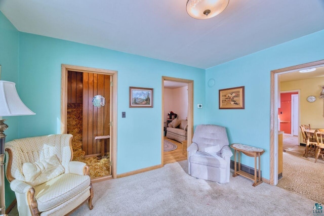 sitting room featuring light carpet and baseboards