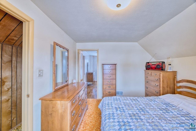 bedroom with vaulted ceiling and a textured ceiling