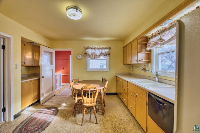 kitchen with black dishwasher, light countertops, a sink, and open shelves