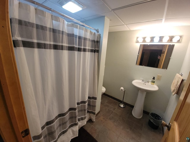 bathroom with a paneled ceiling, a shower with shower curtain, and toilet