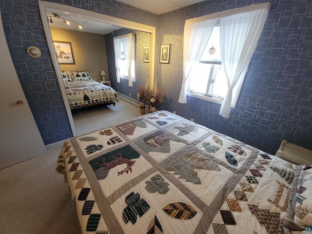 bedroom with a baseboard heating unit and carpet floors