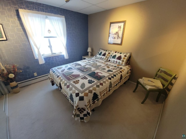 bedroom featuring carpet floors, a drop ceiling, and a baseboard radiator