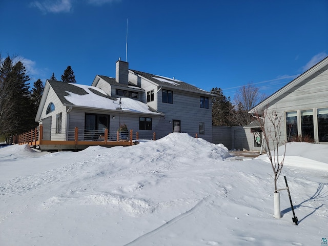 snow covered property with a chimney